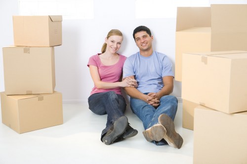 Professional movers loading boxes into a moving van in North West London